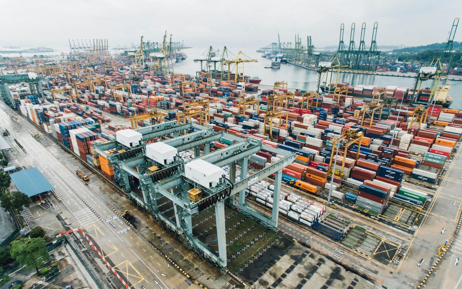 Aerial view of a container yard with rows of stacked shipping containers